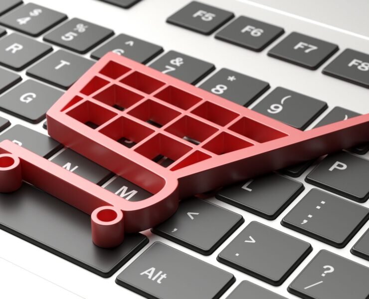 E shop, e commerce concept. Shopping cart trolley icon on a computer laptop. 3d illustration